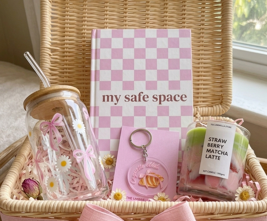 Wicker basket with 'my safe space' notebook, glass jar, keychain, and other items.