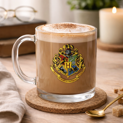 Glass mug with a Harry Potter logo filled with a hot beverage on a wooden table.