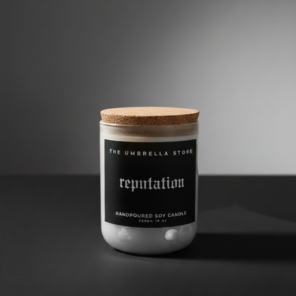 Candle jar with cork lid labeled 'reputation' from 'The Umbrella Store' on a dark background
