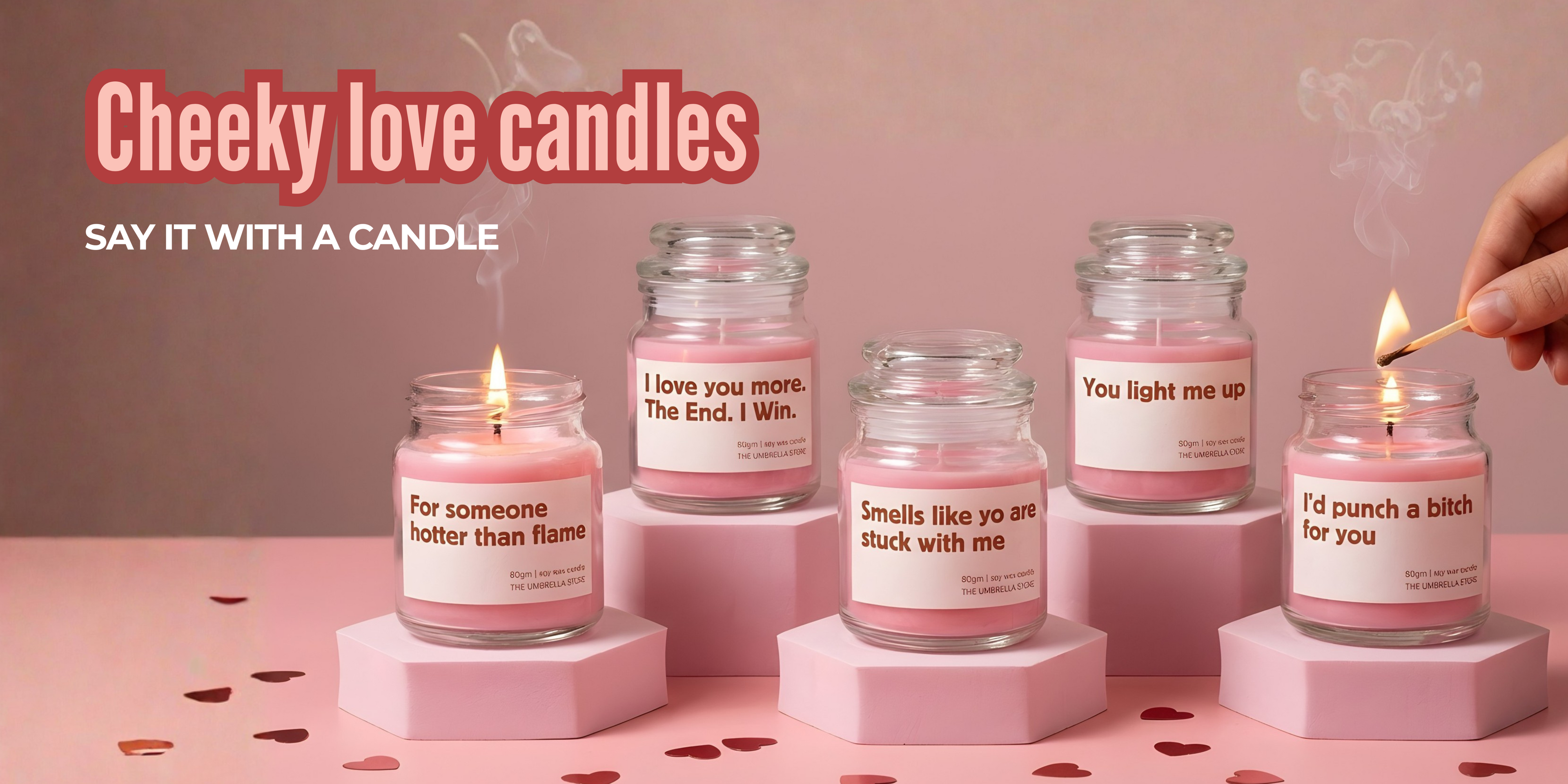 Set of pink candles with humorous labels on a pink background, with a hand lighting one of the candles.